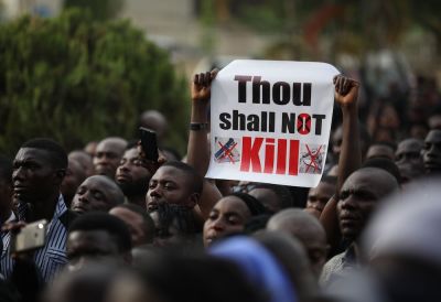 Christians hold signs as they march on the streets of Abuja during a prayer and penance for peace and security in Nigeria in Abuja on March 1, 2020.